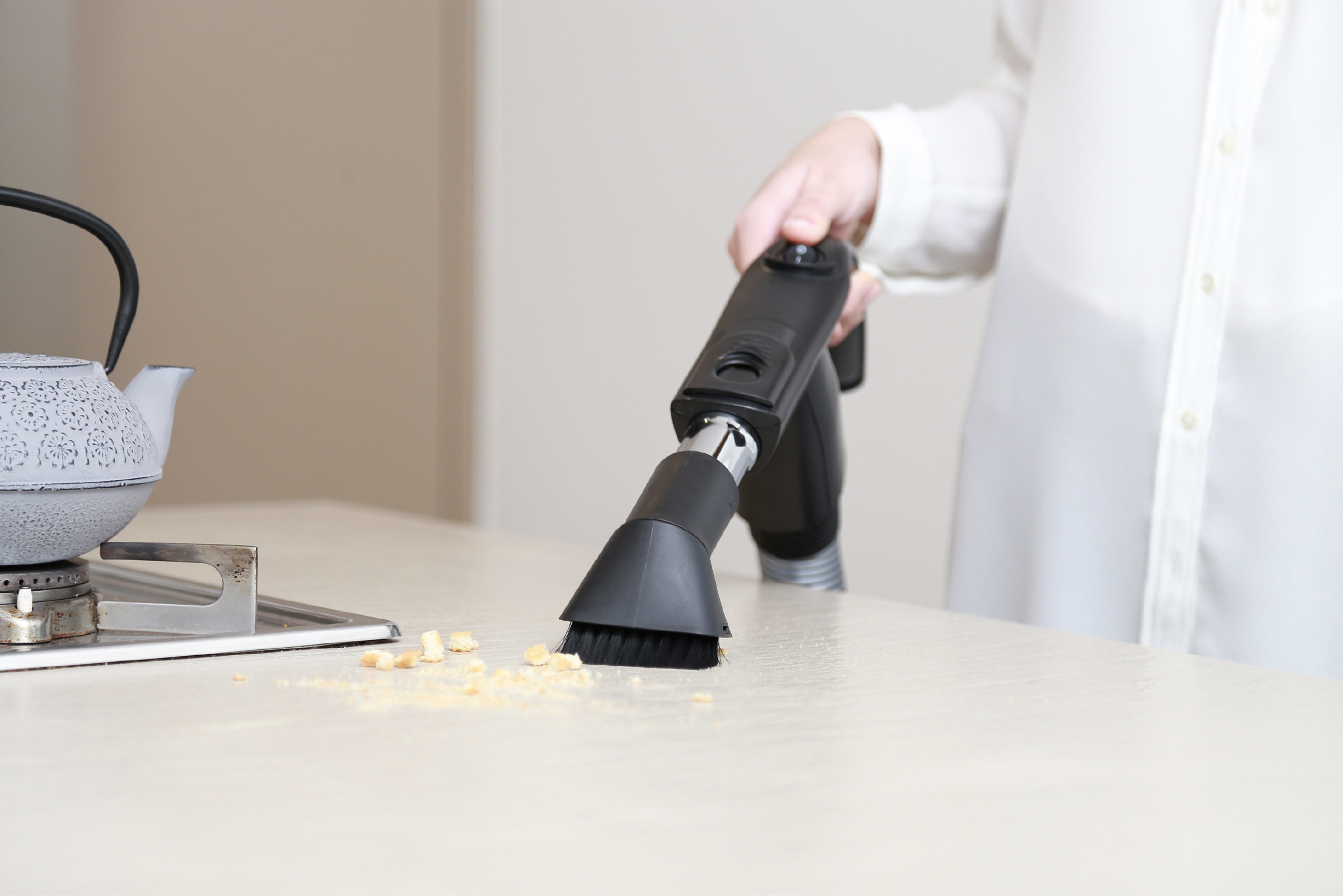 Utilizzo della spazzola per spolverare nel piano di lavoro di una cucina per aspirare delle briciole con l'aspirapolvere centralizzato